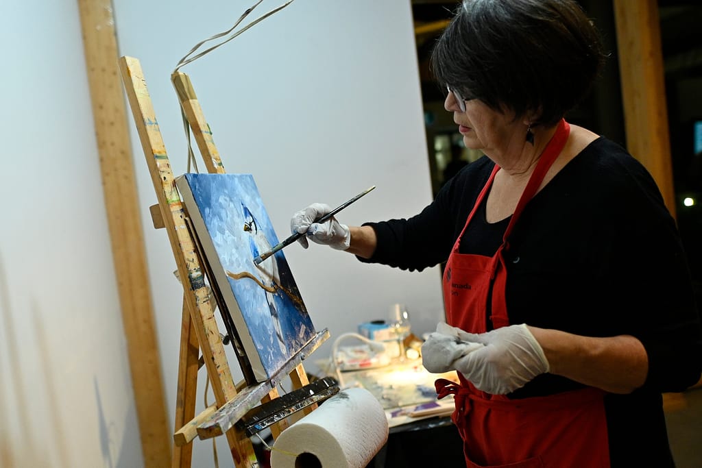 L'artiste-peintre Annette Cormier lors de la réalisation de sa toile en direct.